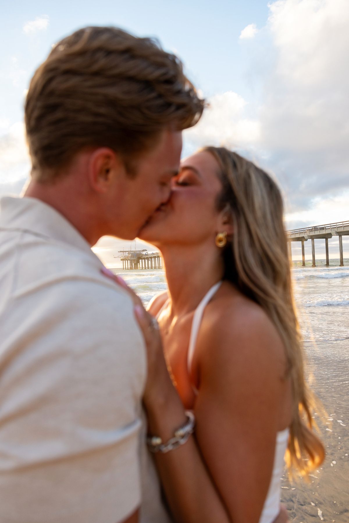 Newly engaged couple kissing at Scripps Pier
